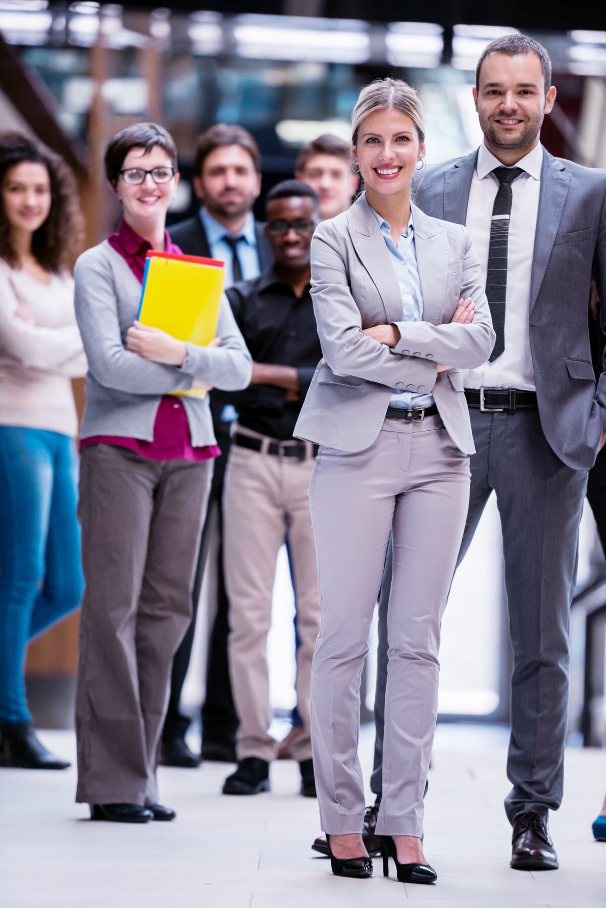 A multi-generational group of professionals walking through a corporate plaza.