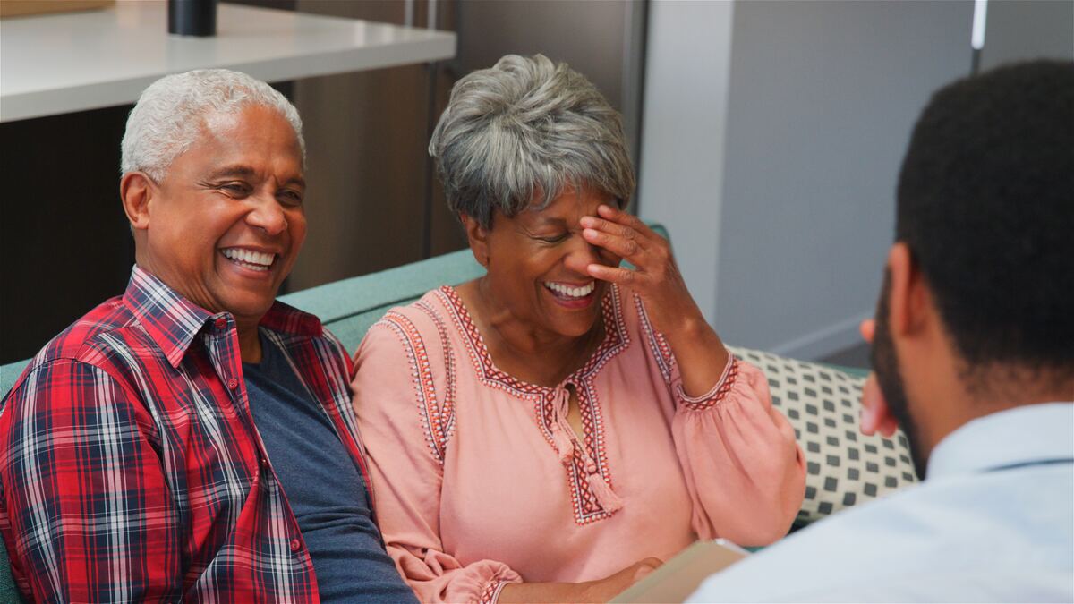 A senior couple in conversation with a younger adult, warm afternoon light.