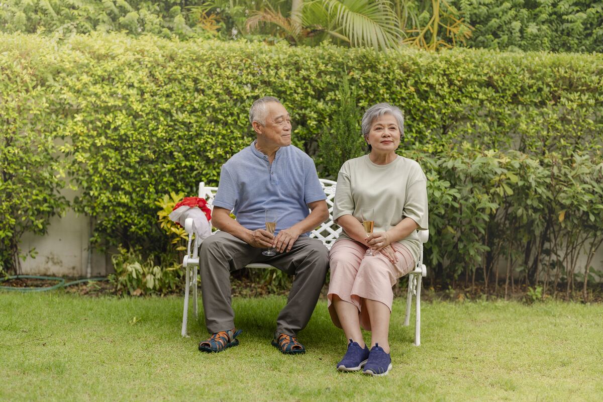 An older couple at an outdoor anniversary moment in golden light.